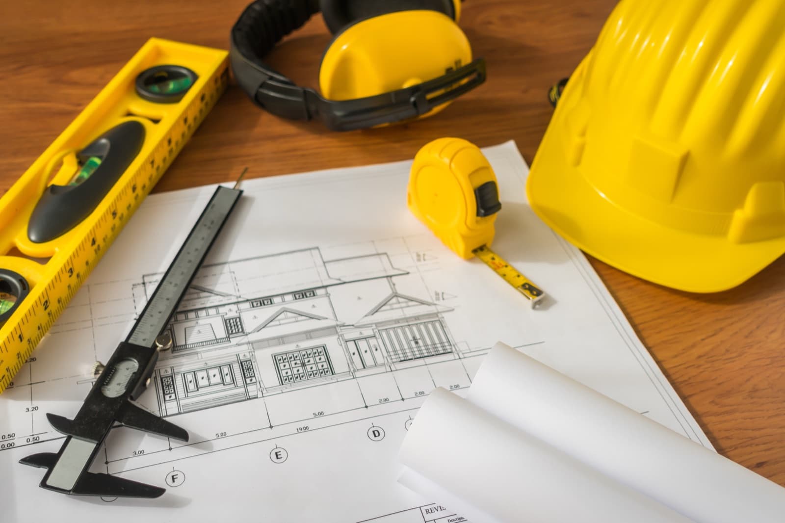 Plans, tape measure and hard hat on a job-site table